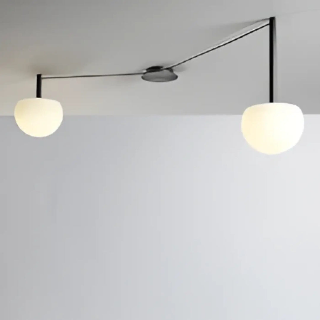 Plafonnier design a trois globes en verre dépoli suspendus par bras noirs pour décoration intérieure univers déco