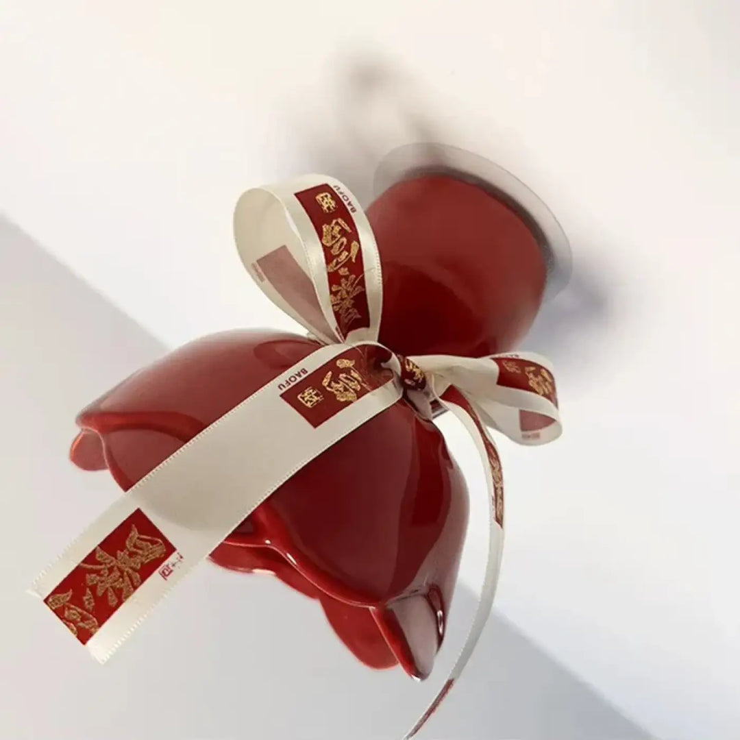 Luminaire plafonnier en céramique rouge brillant avec nœud décoratif blanc et motifs dorés pour décoration intérieure d’un objet pensé