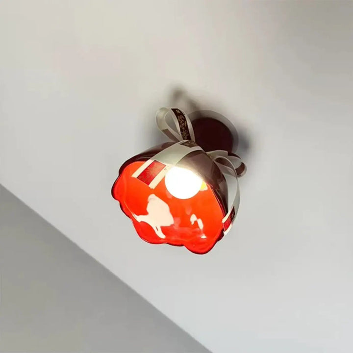 Luminaire plafonnier en verre rouge brillant avec nœud décoratif blanc et silhouette subtile pour décoration intérieure d’un objet pensé