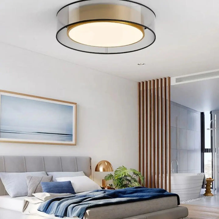 Luminaire plafonnier vadim moderne avec anneaux concentriques en métal noir et or brossé émettant une lueur chaude