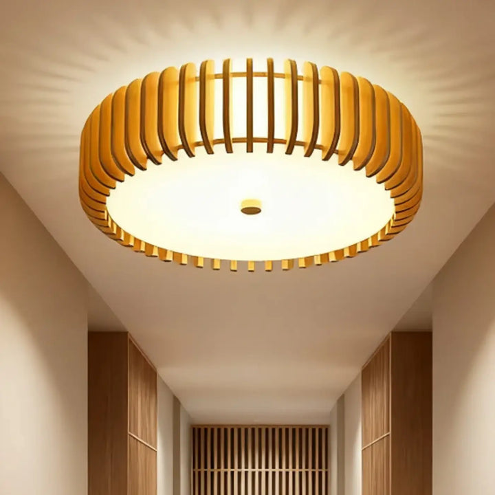 Plafonnier luminaire rond warm ton chaud avec design en bois à lattes pour une ambiance plus qu’un éclairage classique