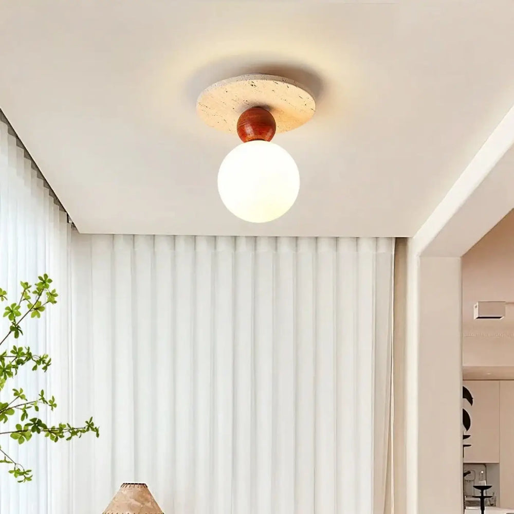 Plafonnier moderne elliptia avec globe en verre dépoli rond, sphère en bois chaud et base en pierre texturée pour salle à manger design minimaliste