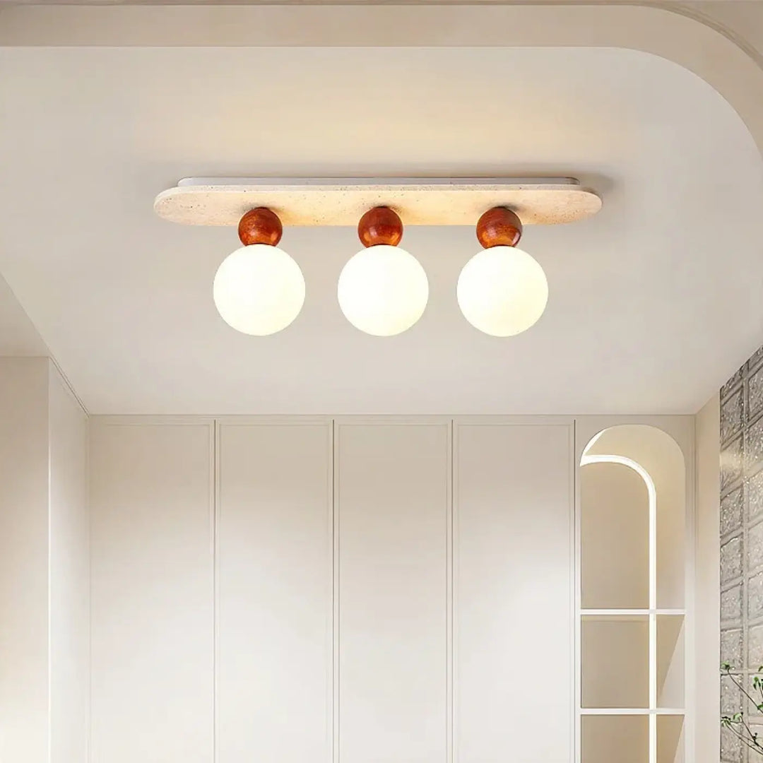 Plafonnier moderne elliptia avec trois globes en verre dépoli sur base en bois blanc cassé pour salle à manger design minimaliste
