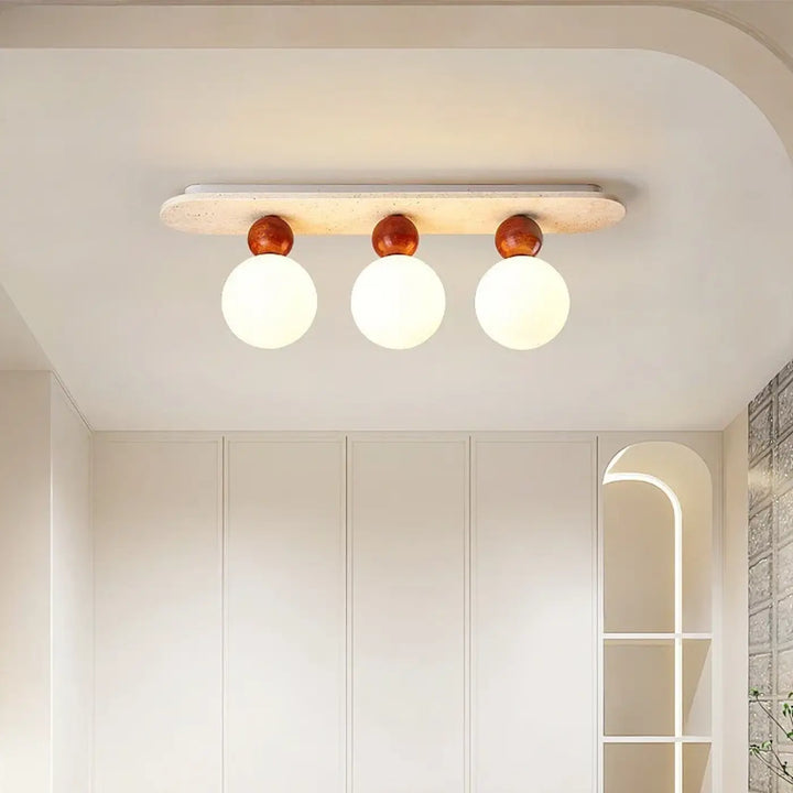 Plafonnier moderne elliptia avec trois globes en verre dépoli sur base en bois blanc cassé pour salle à manger design minimaliste