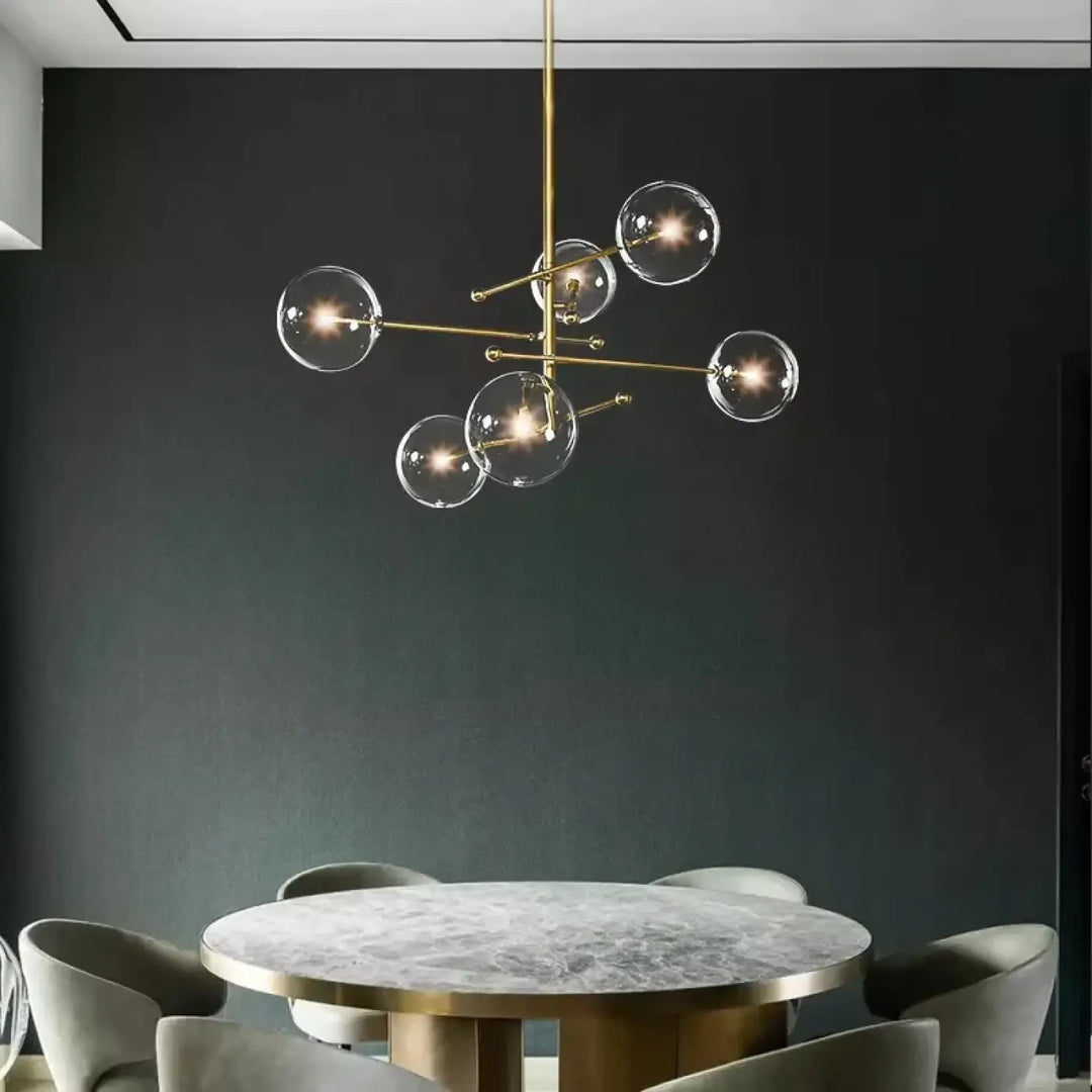Plafonnier moderne atomix en laiton doré avec globes en verre clair idéal pour salle à manger élégante