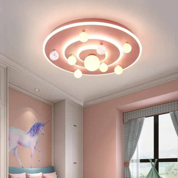 Luminaire plafonnier cosmio rose avec anneaux concentriques et ampoules sphériques pour un plafonnier moderne univers galactique