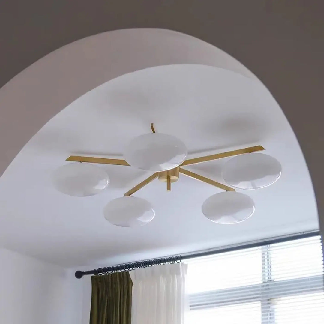 Plafonnier moderne xilys avec cinq globes en verre blanc et bras graphiques en métal doré