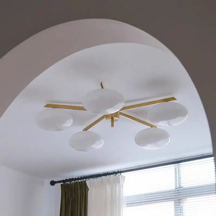 Plafonnier moderne xilys avec cinq globes en verre blanc et bras graphiques en métal doré