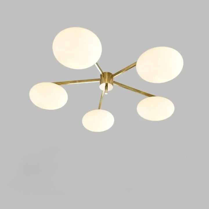 Plafonnier moderne xILYS en laiton finition avec cinq globes en verre blanc et bras graphiques élégants