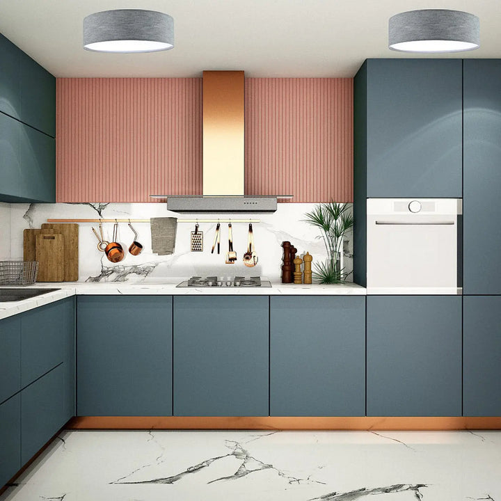 Luminaire plafonnier mesh gris béton avec tissu gris dans une cuisine moderne aux armoires bleu foncé et accents cuivre