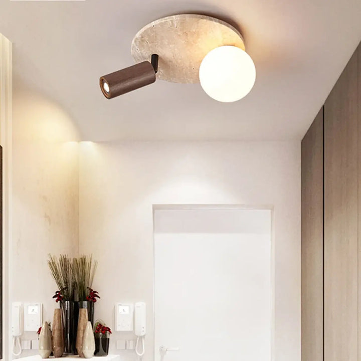 Luminaire plafonnier medier avec base en béton texturé, spot orientable bronze mat et globe en verre opalin design minimaliste