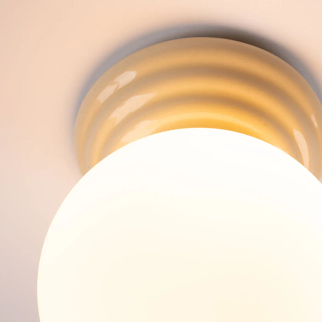 Plafonnier zori beige en céramique crème avec base nervurée et globe blanc lisse pour une belle décoration aux qualités esthétiques