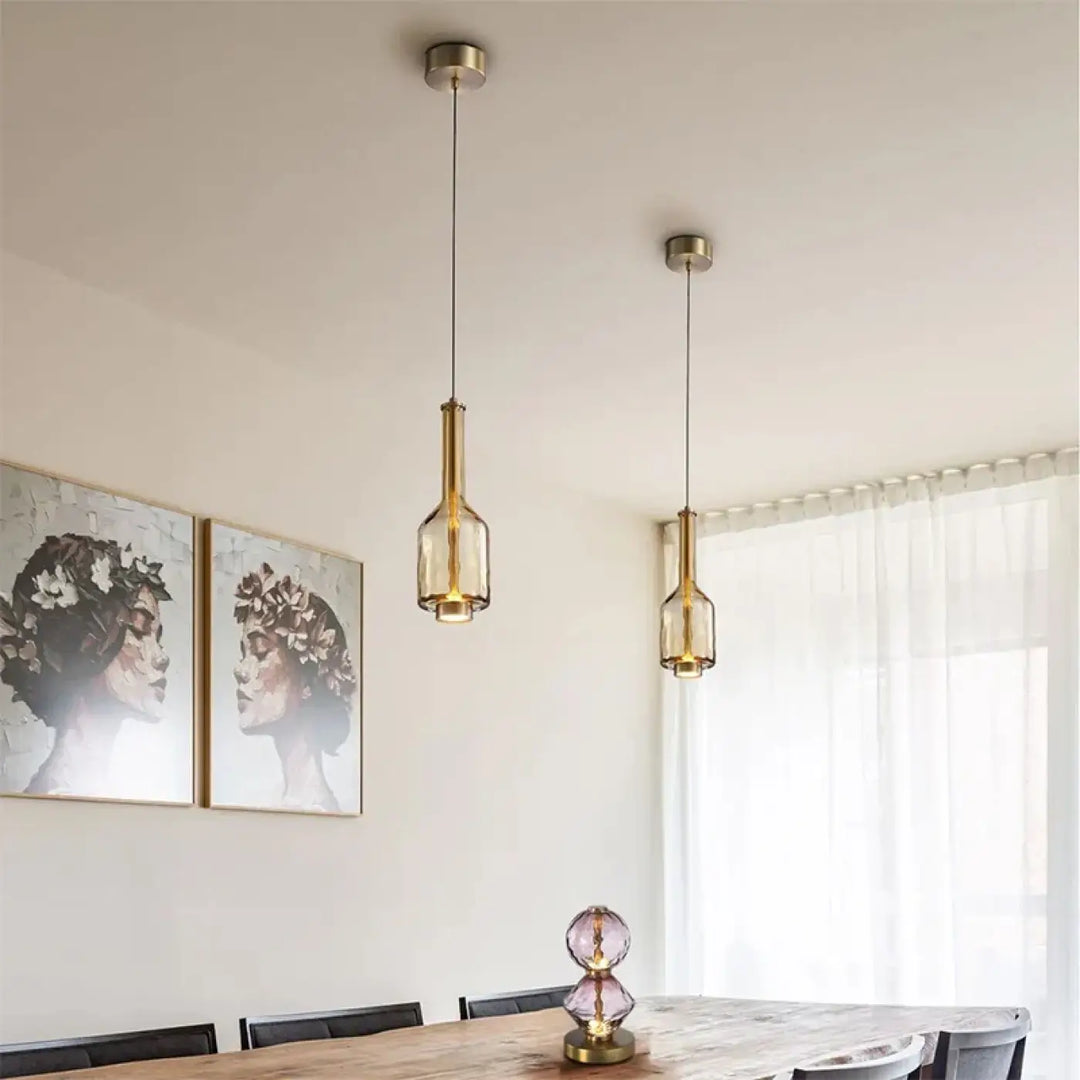 Suspension luminaire slira avec deux luminaires suspendus en métal doré et verre soufflé clair en forme de bouteille