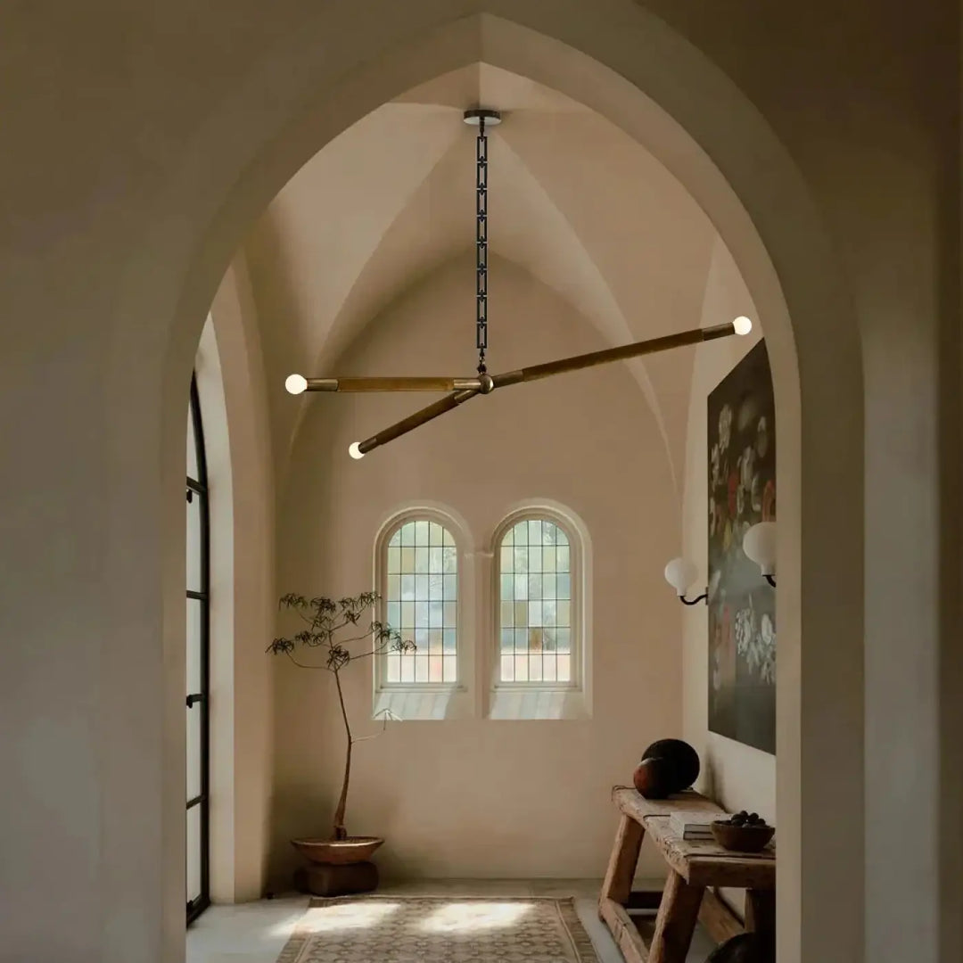 Suspension luminaire pika avec design asymétrique en laiton et globes lumineux blancs suspendus par chaîne noire