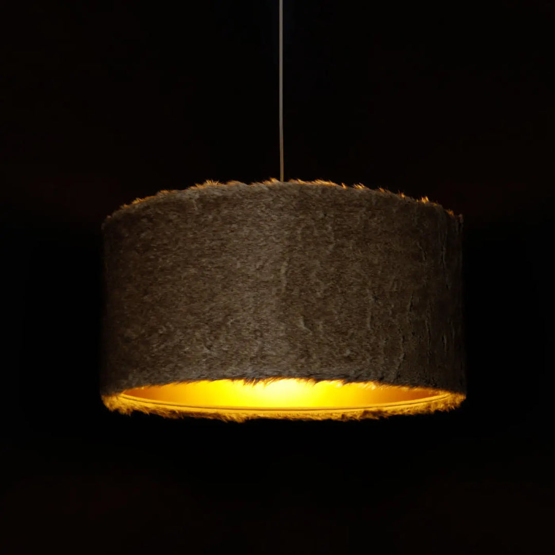 Suspension luminaire bear light beige avec une lampe pendante cylindrique texturée gris foncé et lumière intérieure jaune chaleureux