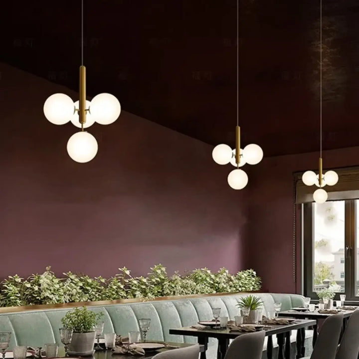 Suspension luminaire dinah avec tiges en laiton et trois globes ronds en verre blanc dépoli milky white glass