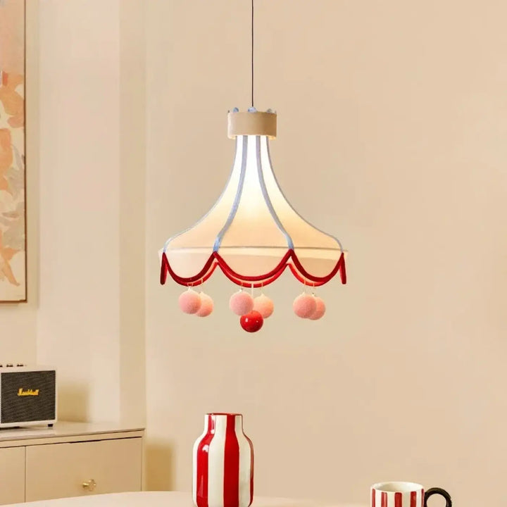 Suspension luminaire circus design inspiré avec lumière douce crème bordée de rouge et pompons roses et rouges suspendus