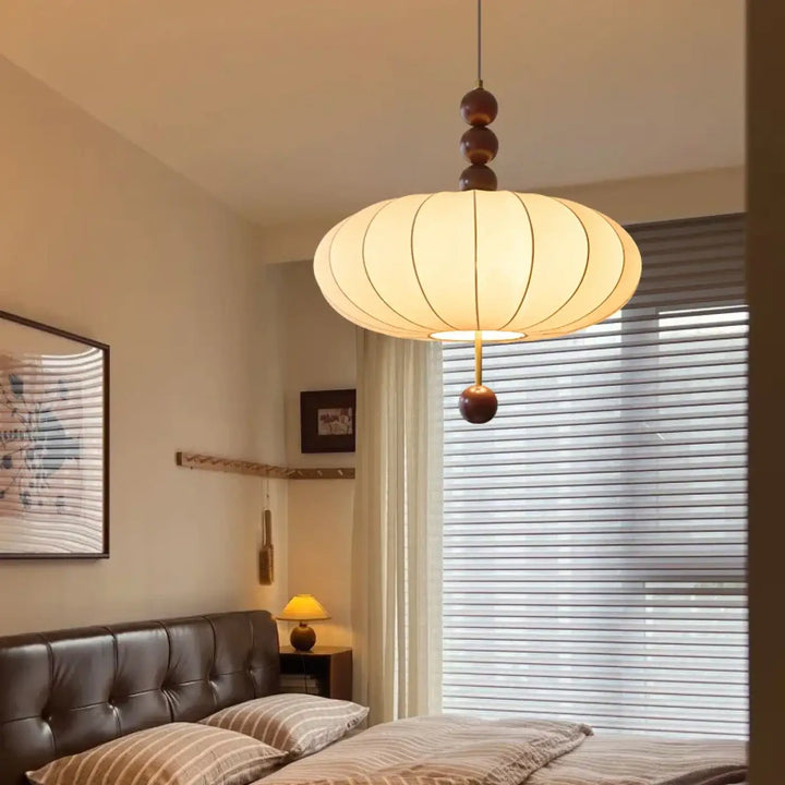 Suspension design en tissu beige et boules de bois modernes

