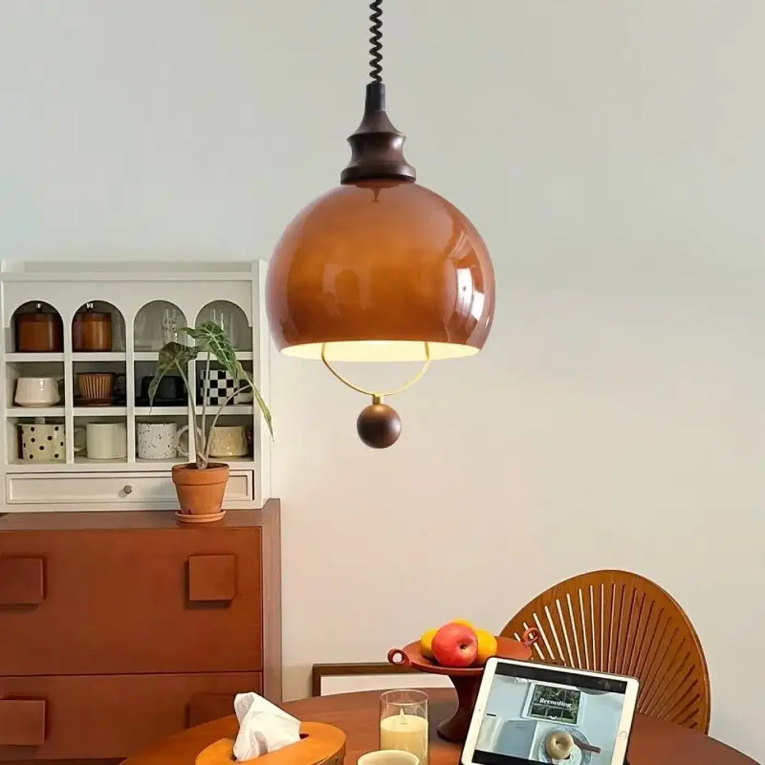 Suspension globe ambrée avec détail doré et boule décorative

