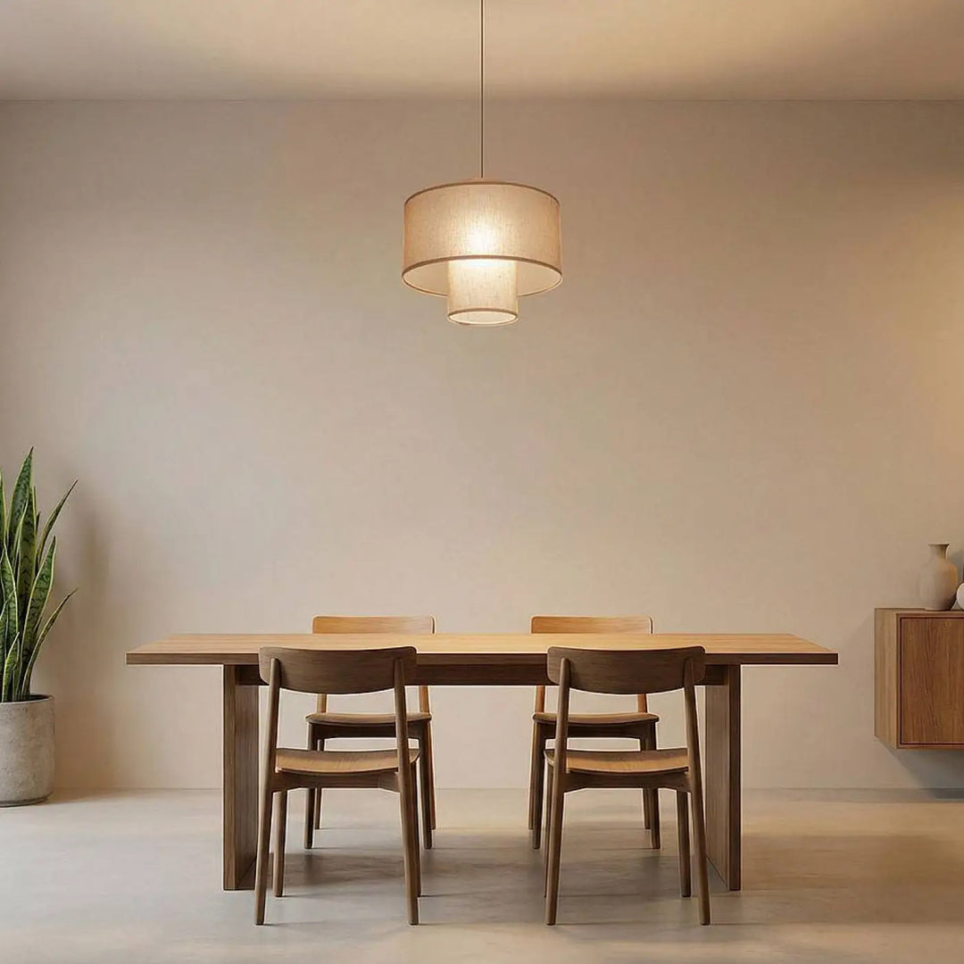 Suspension luminaire twin marron clair avec double abat-jour en lin double cylindrique au-dessus d’une table en bois minimaliste