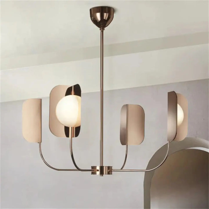 Suspension luminaire copra avec métal doré rose et globes opalins sphériques encadrés de structures courbes modernes