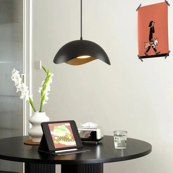 Suspension luminaire eloria en finition mate noire avec intérieur chaud aux courbes ondulées pour ambiance élégante