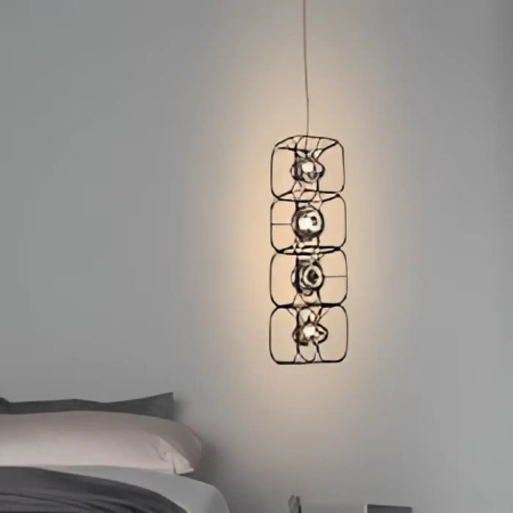 Suspension luminaire axoria en métal noir avec quatre cadres carrés empilés et ampoules circulaires aux formes graphiques