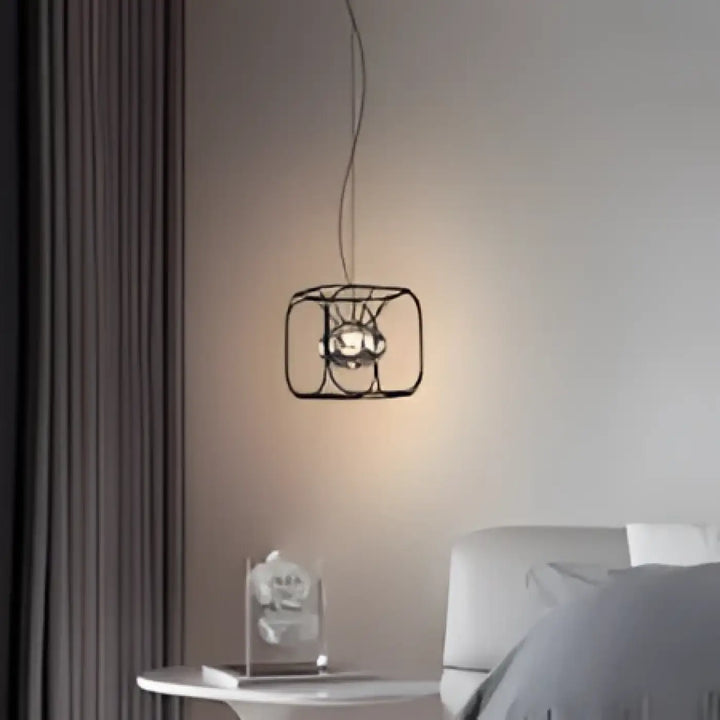 Suspension luminaire industriel axoria avec cadre en métal noir et ampoule à ton chaud aux formes graphiques