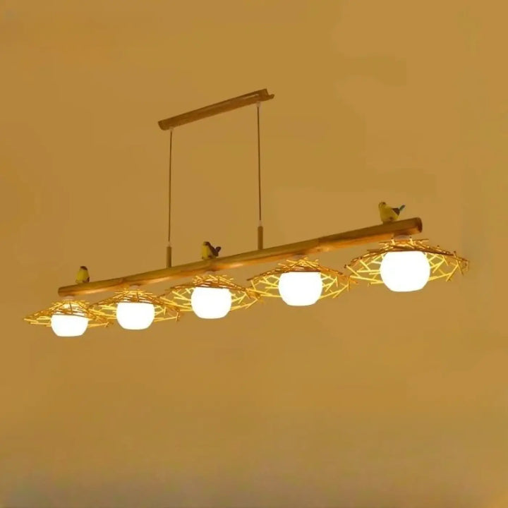 Suspension luminaire volantis en bambou rustique avec quatre ampoules globes blanc chaud dans des nids tissés ornés d oiseaux jaunes