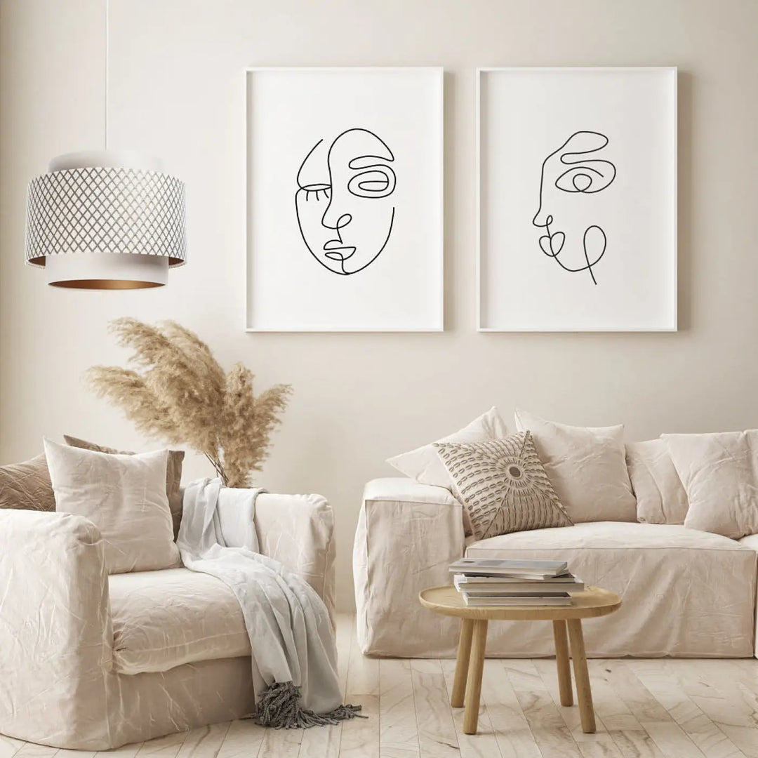 Deux estampes minimalistes de visages en lignes noires dans des cadres blancs illustrent un suspension luminaire blanc crème doblo
