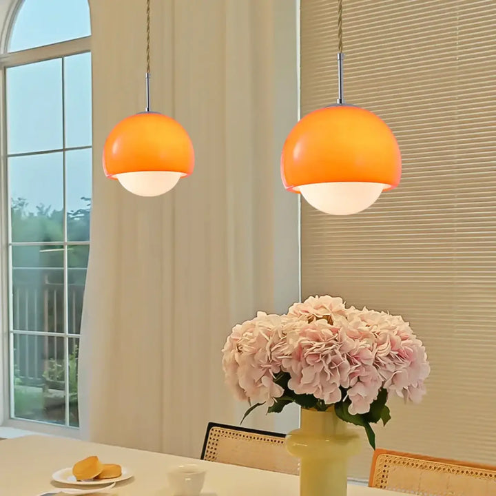 Suspension luminaire orana avec deux luminaires orange en forme de dôme et bases en verre dépoli pour lumière douce