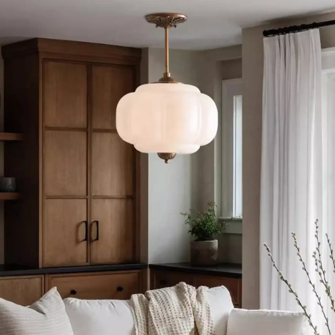Suspension luminaire contemporaine en verre opale blanc cassé avec monture métal finition laiton et détail décoratif supérieur