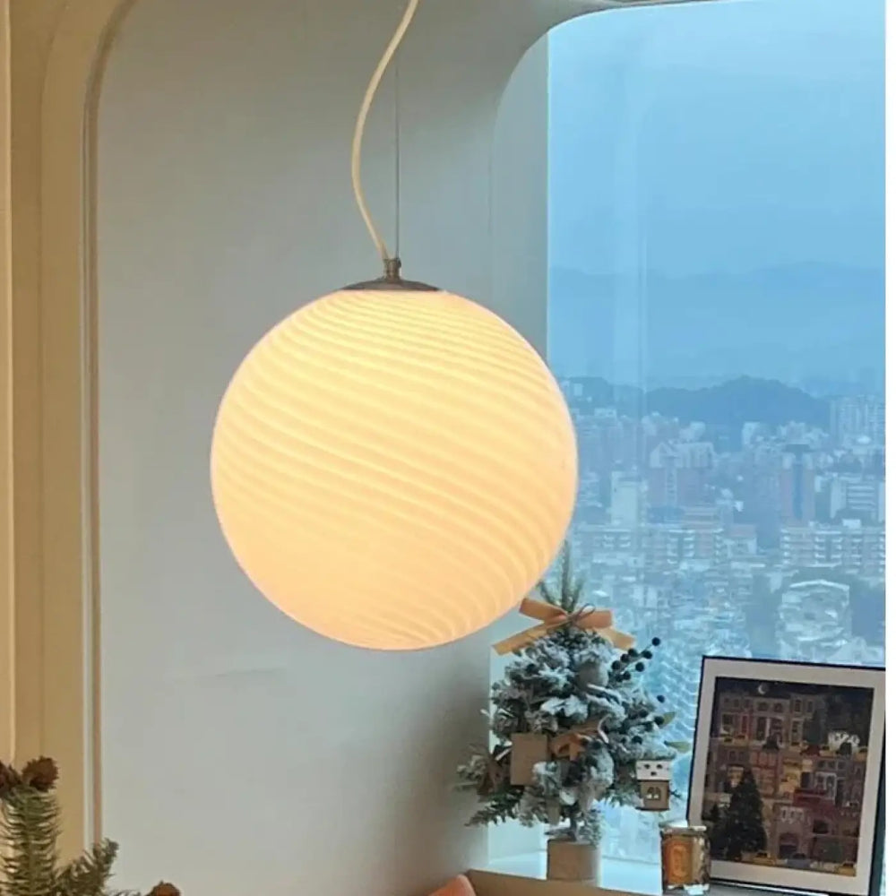 Suspension luminaire lolly spherical warm-toned with ribbed texture and soft glow luminaire contemporaine