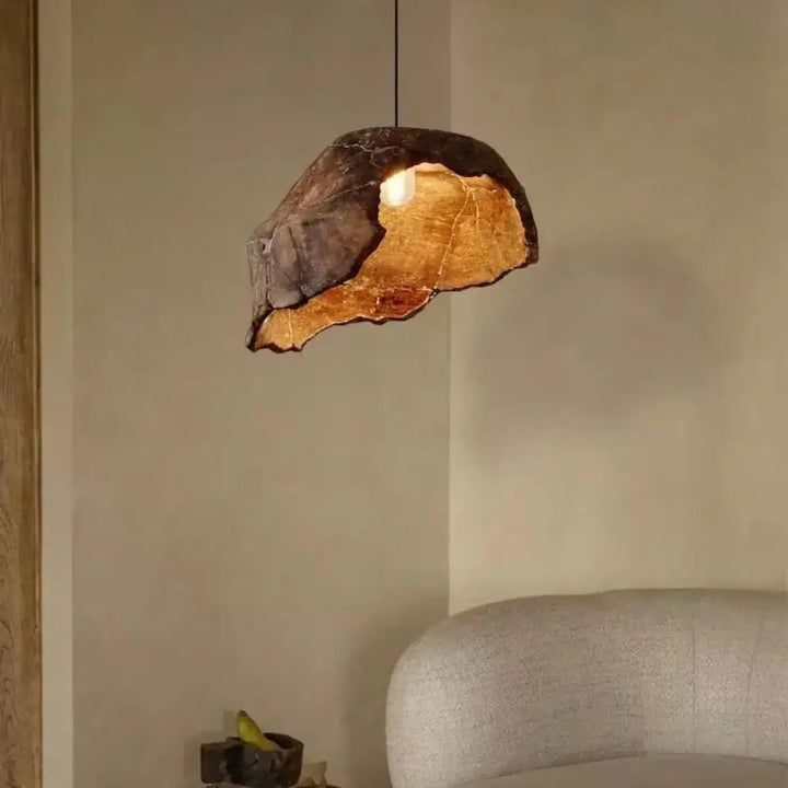 Suspension luminaire litha en forme irrégulière avec coque extérieure sombre texturée et intérieur doré chaleureux