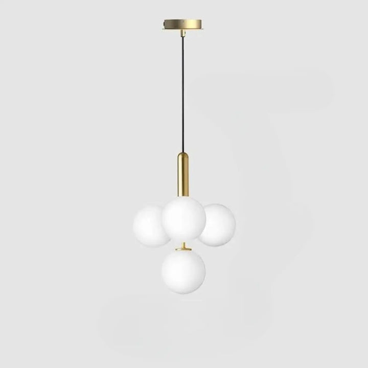 Suspension luminaire contemporaine golys avec quatre sphères en verre givré sur structure métal finition laiton