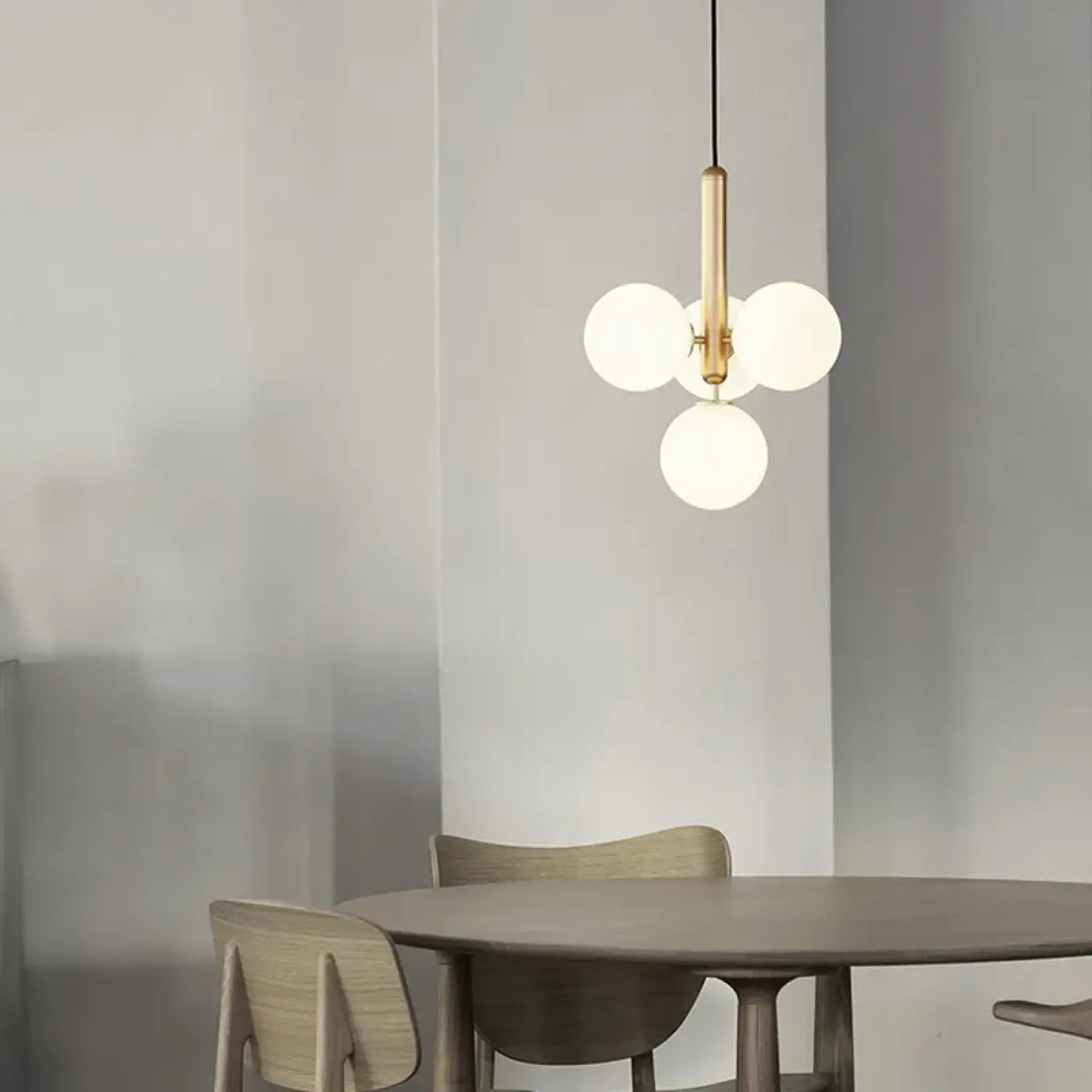 Suspension luminaire contemporaine golys avec tige centrale finition laiton et trois globes en verre givré apporte un luminaire design
