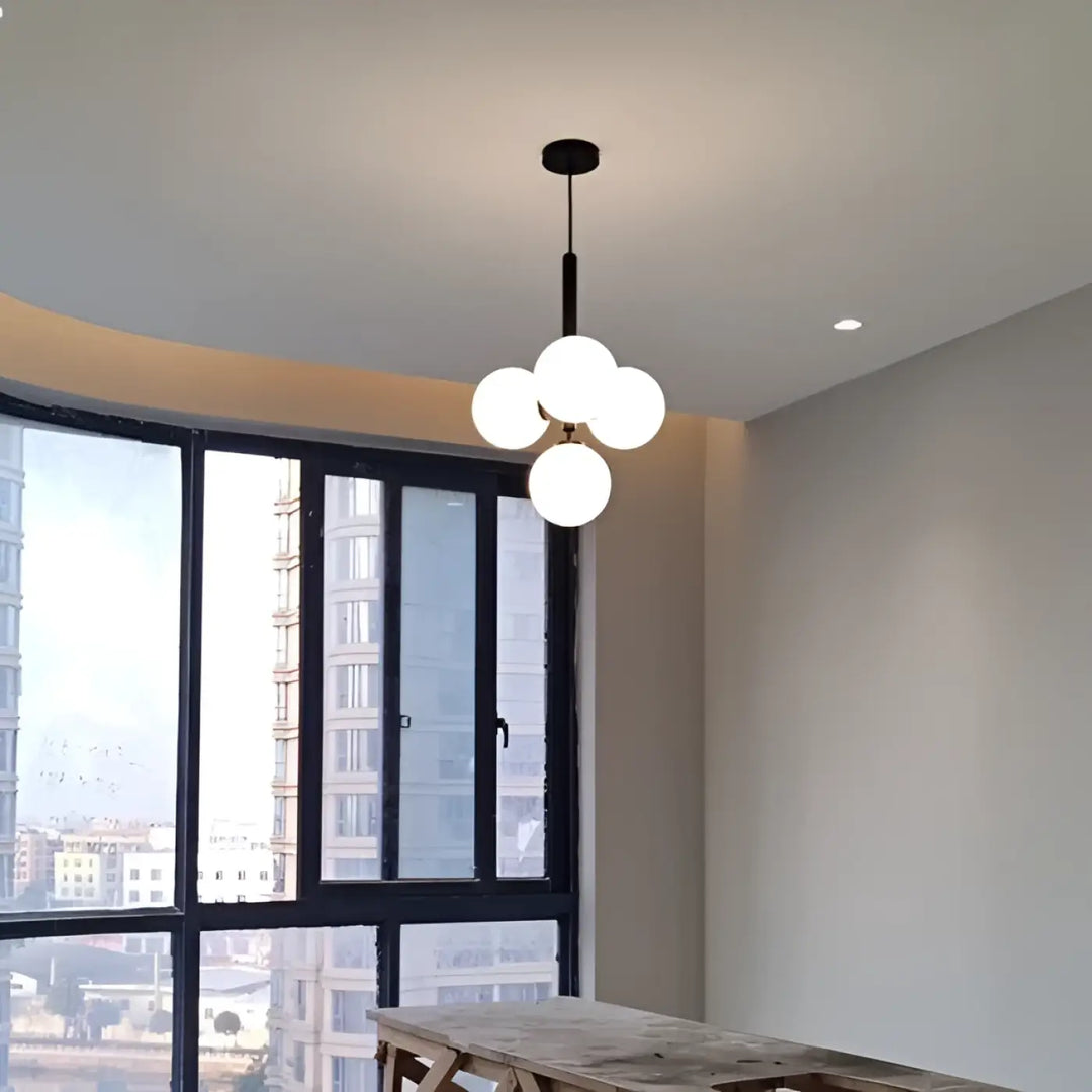 Suspension luminaire contemporaine golys noir avec quatre globes en verre givré apporte un luminaire design élégant