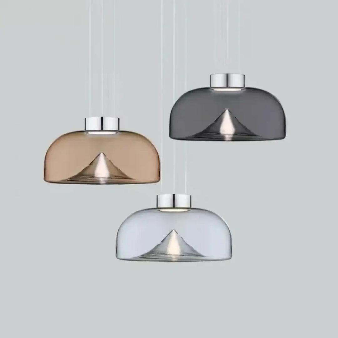 Suspension luminaire eclari avec trois abat-jours en verre transparent fumé ambre, gris et clair au design moderne