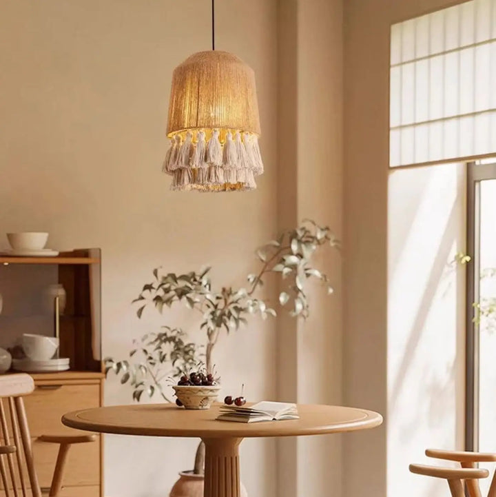 Suspension luminaire warm-toned en corde naturelle avec franges décoratives tissées et pompons sous le luminaire bohobo