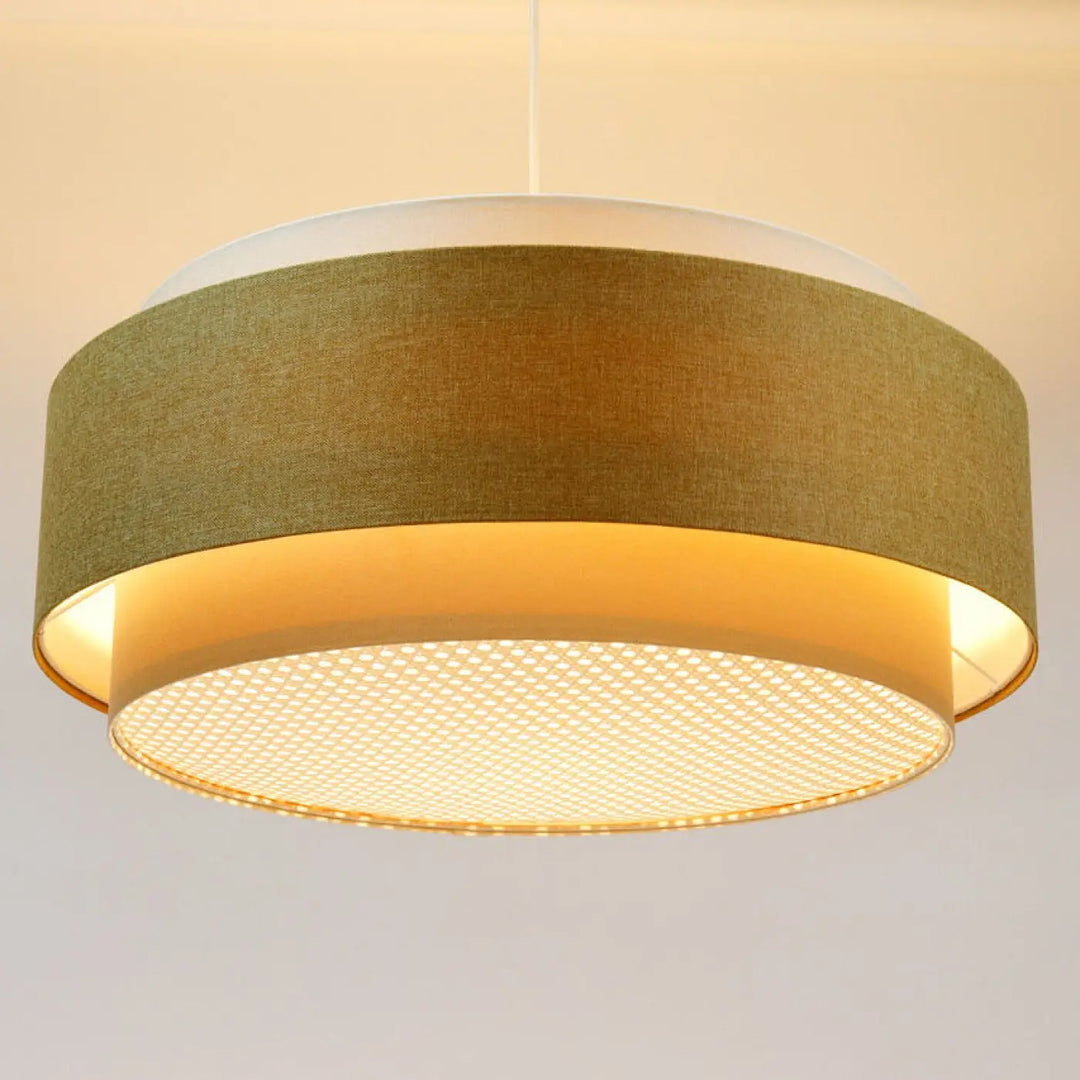 Suspension luminaire doblo boho elegant en tissu vert olive avec diffuseur en maille dorée et anneau blanc au-dessus d’une table