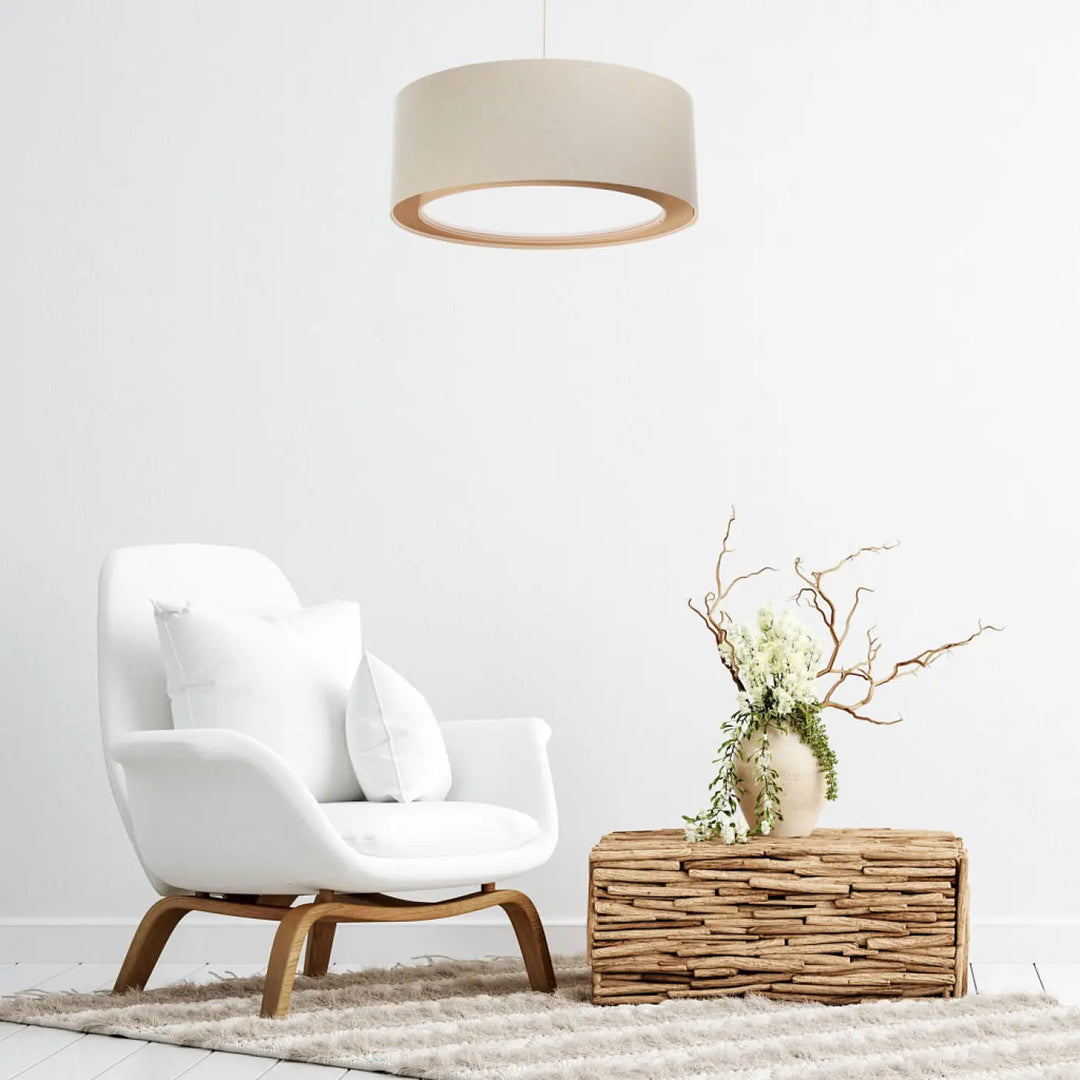 White upholstered armchair with wooden legs displayed alongside a suspension luminaire crème duo boho