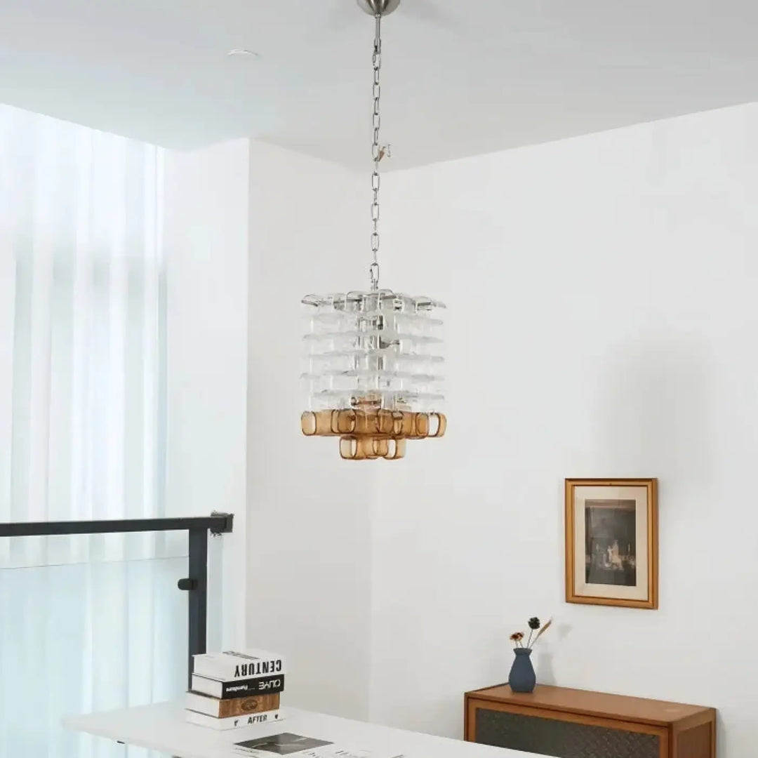 Suspension luminaire lumia avec tiers en verre clair et accents métalliques ambrés suspendue par chaîne au plafond