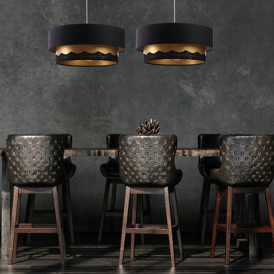Suspension luminaire cylindrique noire avec bords intérieurs en feuille d or dentelée suspendue au-dessus d une table à manger