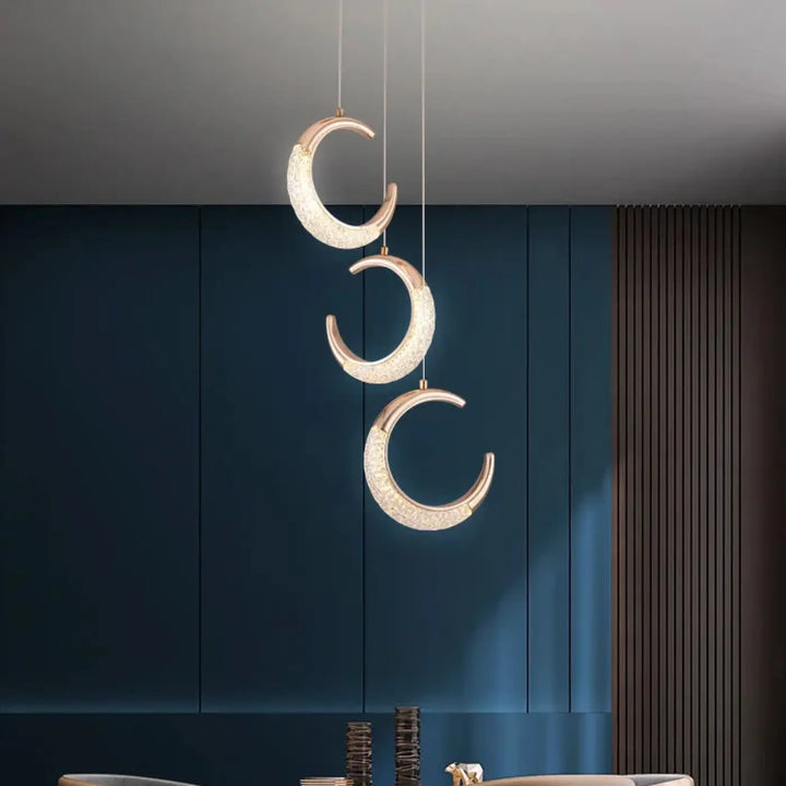Suspension luminaire aluna avec trois pendentifs crescent en metal dore et cristaux decoratifs en ordre descendant