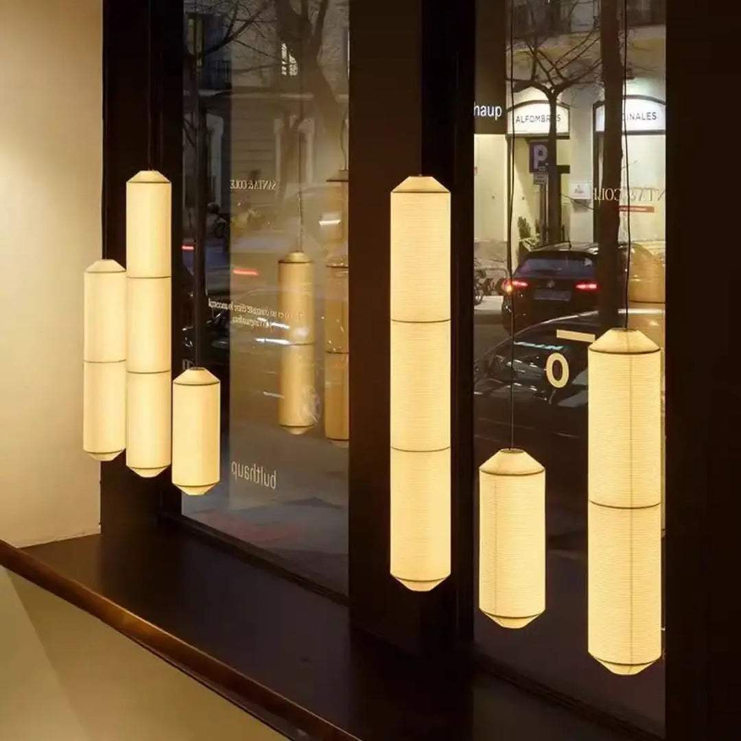 Suspension luminaire paperia avec lumière douce et cylindrique suspendue élégamment au-dessus d’une table en papier