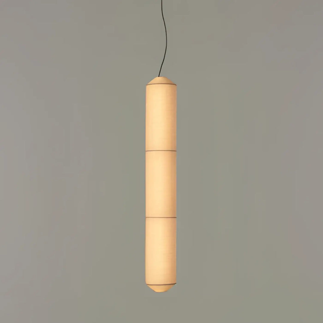 Suspension luminaire cylindrique en papier avec lumière douce chaleureuse au-dessus d’une table