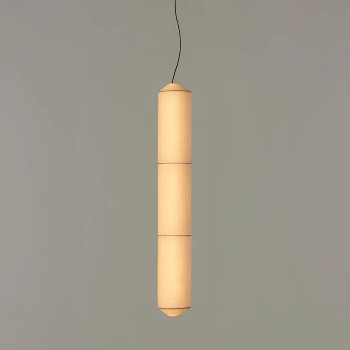 Suspension luminaire cylindrique en papier avec lumière douce chaleureuse au-dessus d’une table