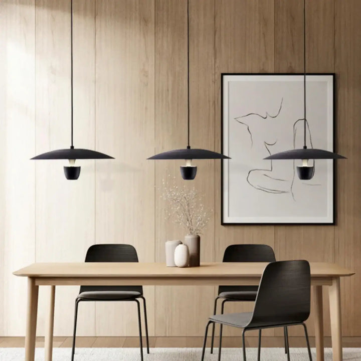 Trois suspensions luminaire habaka noires élégantes avec abat-jour minimaliste en disque au-dessus d’une table en bois sans frais supplémentaires