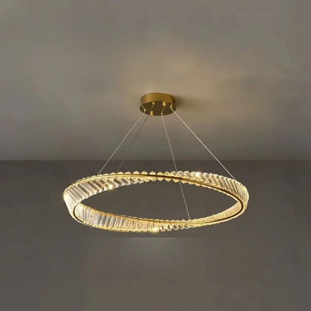 Lustre circulaire ton doré aux accents de cristal facetté et à un design moderne et minimaliste.
