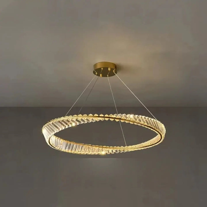 Lustre circulaire ton doré aux accents de cristal facetté et à un design moderne et minimaliste.
